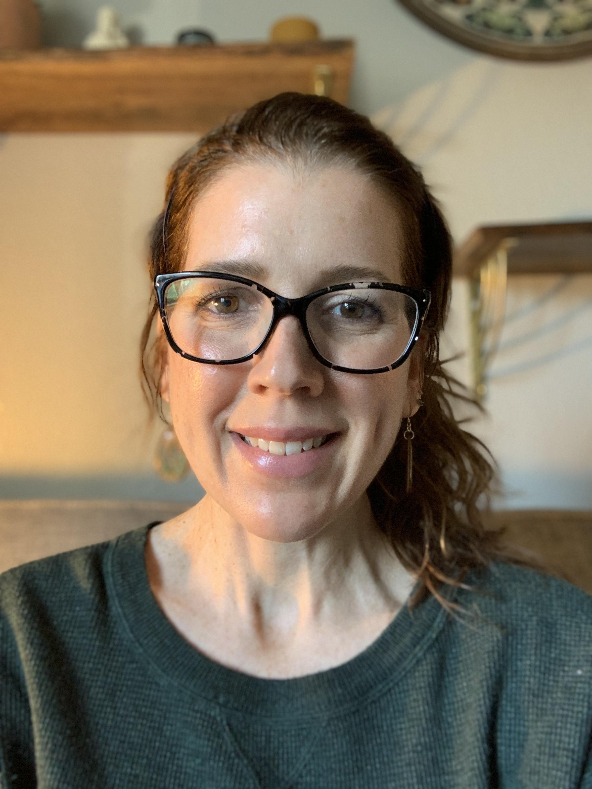 Jill Terra-Chesnut wearing a green and gray shirt and glasses